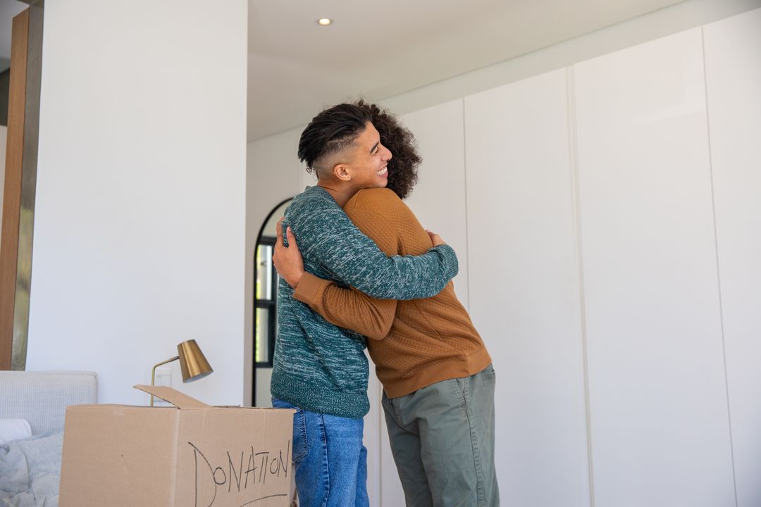 People Hugging Near Donation Box at Home Indicating Care and Support