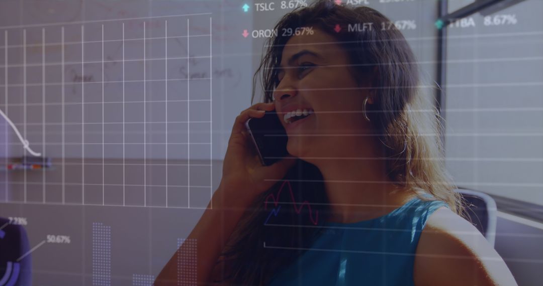 Smiling Businesswoman Engaged in Call with Graphs Displayed