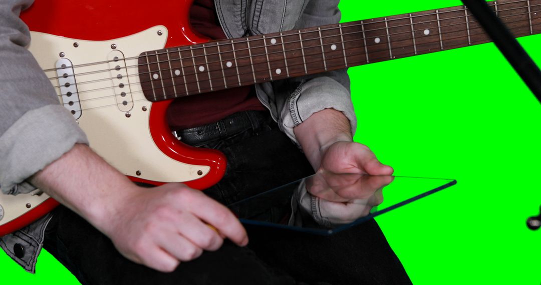 Musician On Green Screen Holding Tablet with Electric Guitar - Free Images, Stock Photos and Pictures on Pikwizard.com