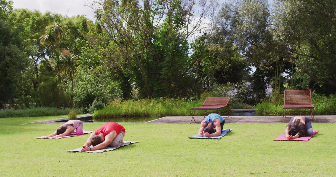 Diverse Group Practicing Yoga on Mats in Serene Park Setting