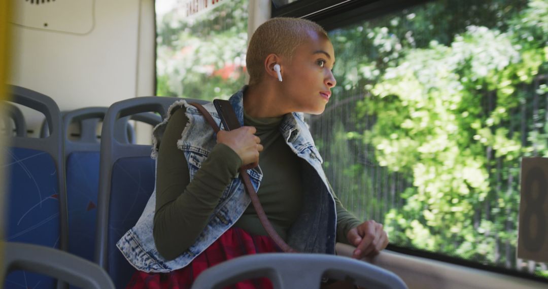 Young Woman Riding Bus with Headphones, Looking Out Window Thoughtfully - Free Images, Stock Photos and Pictures on Pikwizard.com