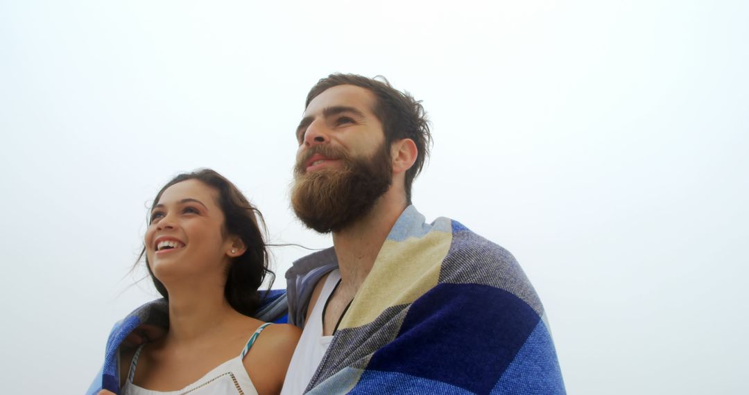 Romantic Couple Enjoying Ocean Breeze Under Blanket
