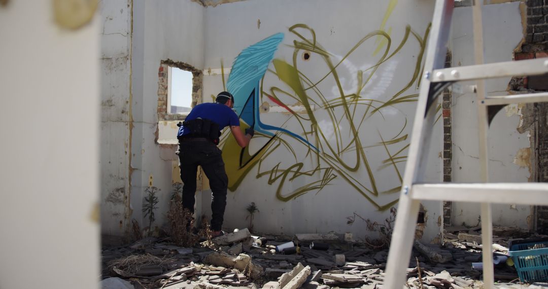 Street Artist Creating Colorful Graffiti in Abandoned Building - Free Images, Stock Photos and Pictures on Pikwizard.com