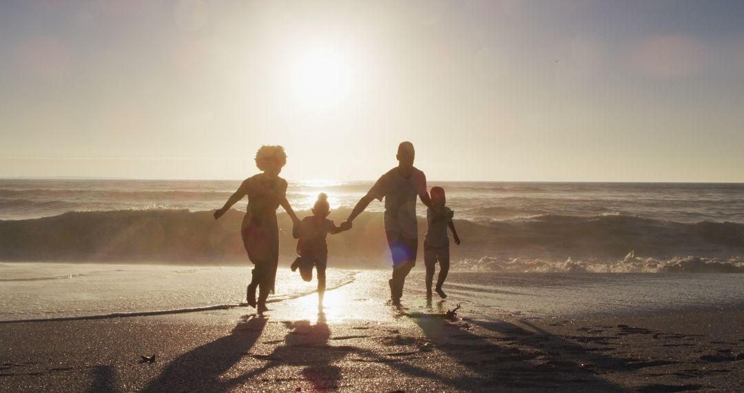 Silhouette of Family Running on Beach at Sunset - Free Images, Stock Photos and Pictures on Pikwizard.com