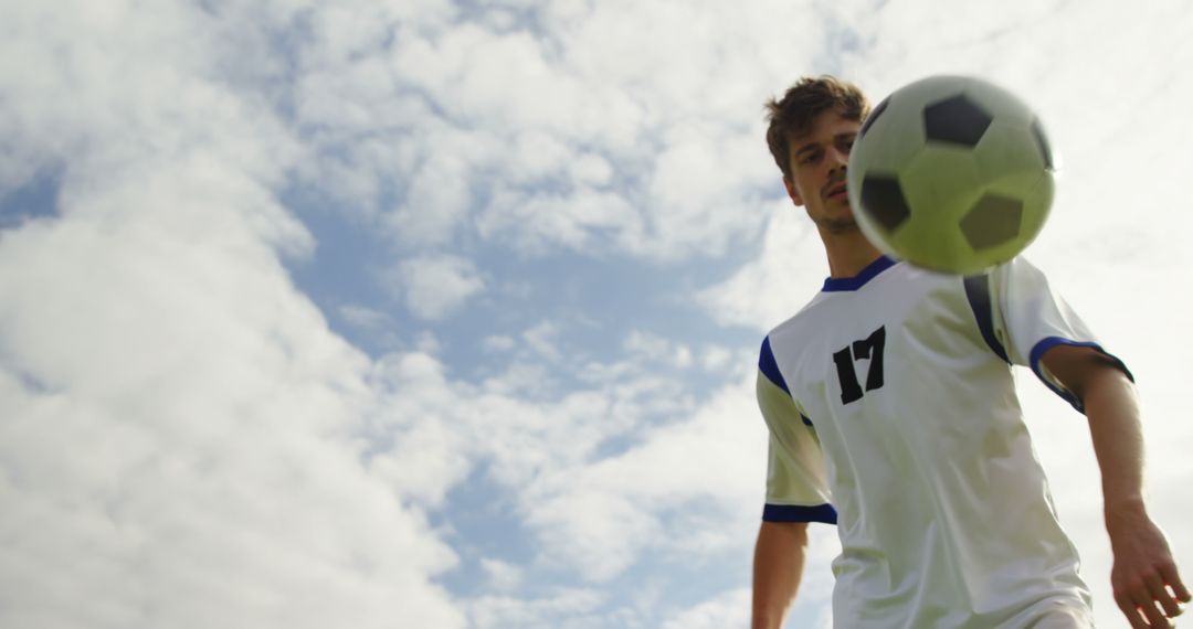 Soccer Player Practicing with Ball Against Blue Sky - Free Images, Stock Photos and Pictures on Pikwizard.com