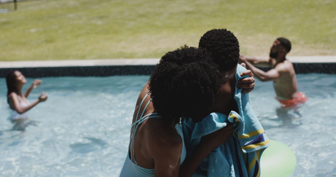 Mother Drying Son with Towel by Pool on Sunny Day