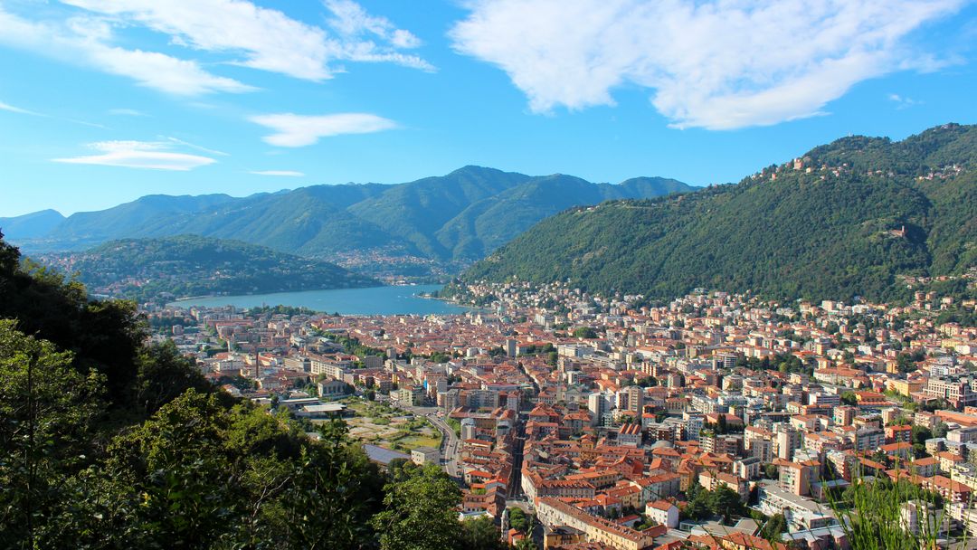 Scenic View of Lake Como Surrounded by Mountains and Cityscape
