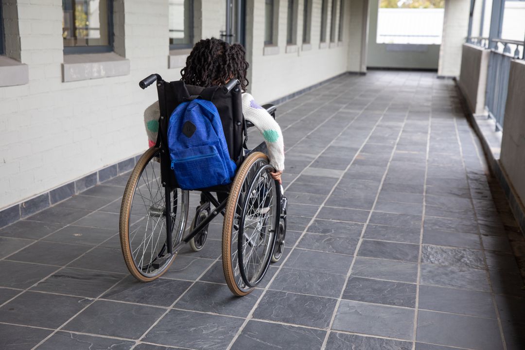 Child Rolling in School Corridor with Backpack, Promoting Inclusivity