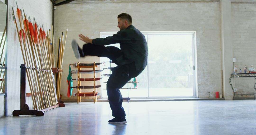 Martial Artist Practicing Kicking Technique in Dojo - Free Images, Stock Photos and Pictures on Pikwizard.com