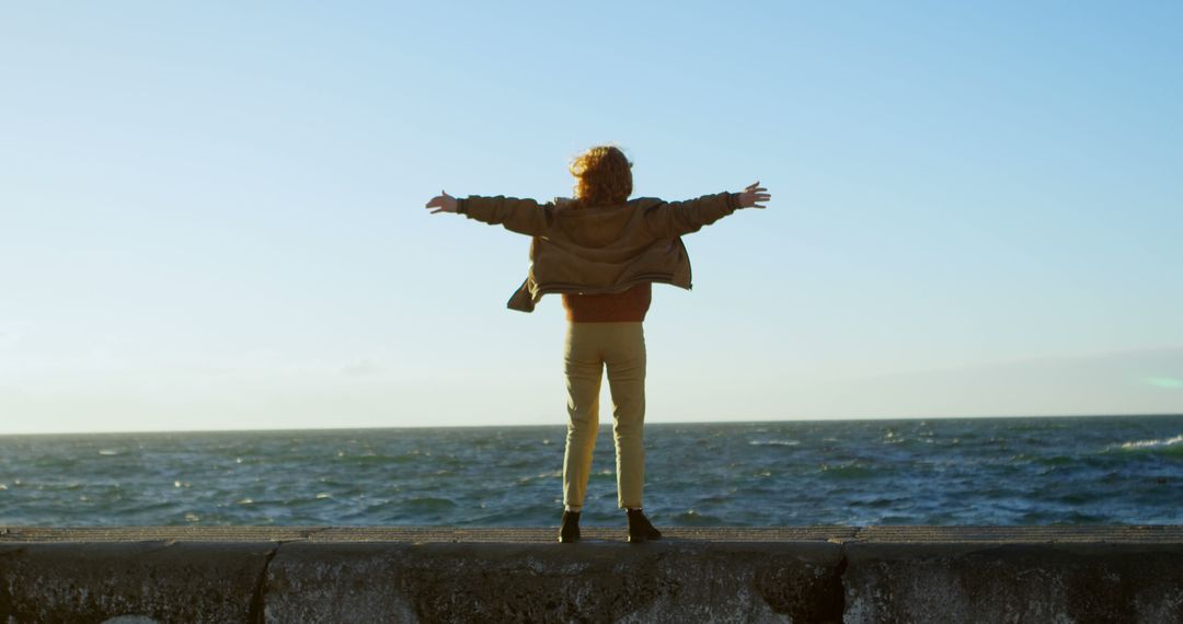 Child Enjoying Freedom on Seaside Barrier - Free Images, Stock Photos and Pictures on Pikwizard.com