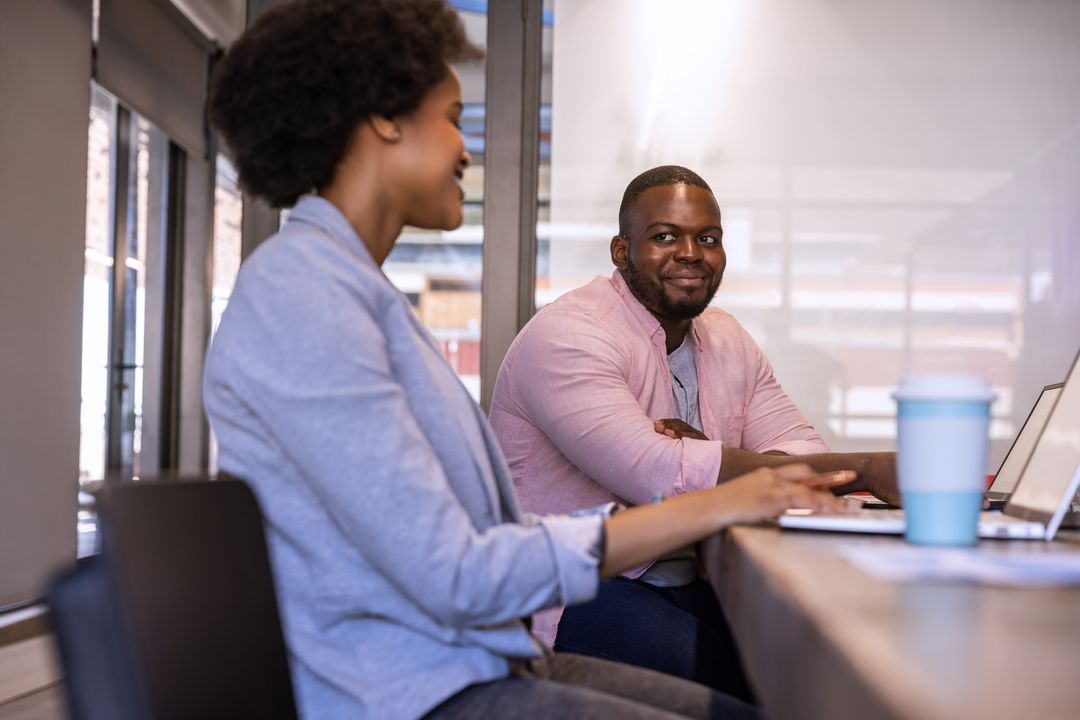 African American Professionals Collaborating in Modern Office with Technology
