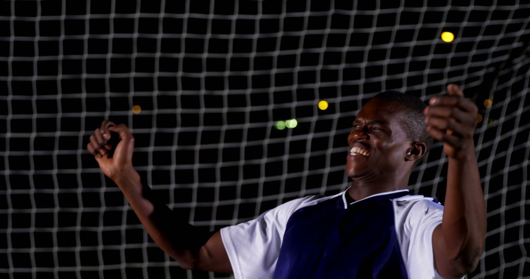 Joyful Soccer Player Celebrating Victory Under Stadium Lights at Night - Free Images, Stock Photos and Pictures on Pikwizard.com