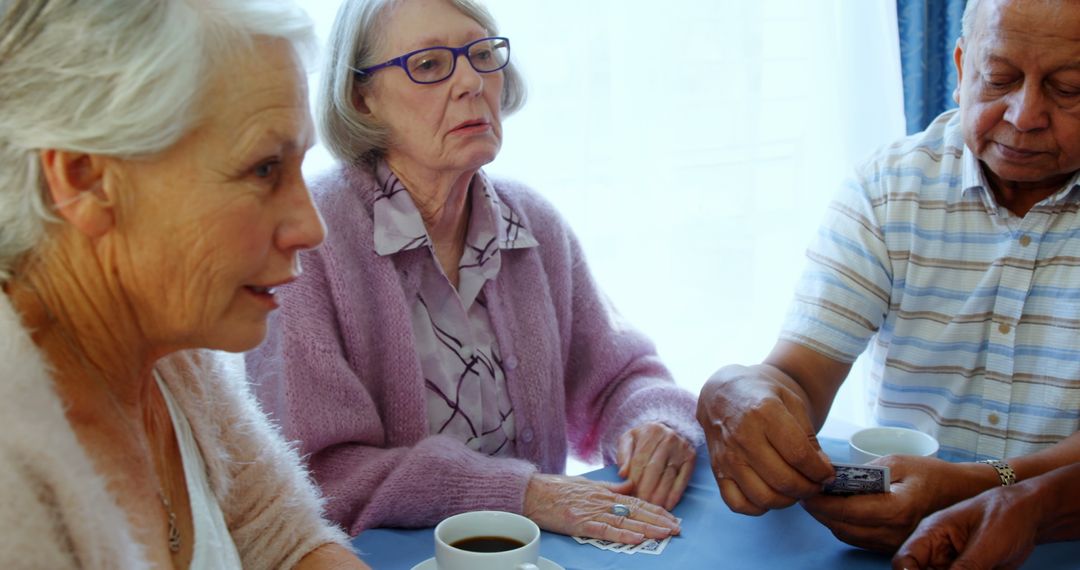 Seniors Playing Cards in Nursing Home Enjoying Friendly Interaction