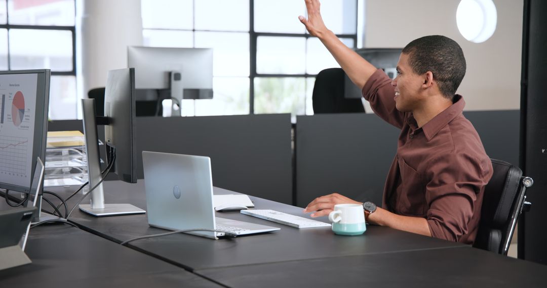 Smiling Businessman Working in Modern Office, Raising Hand