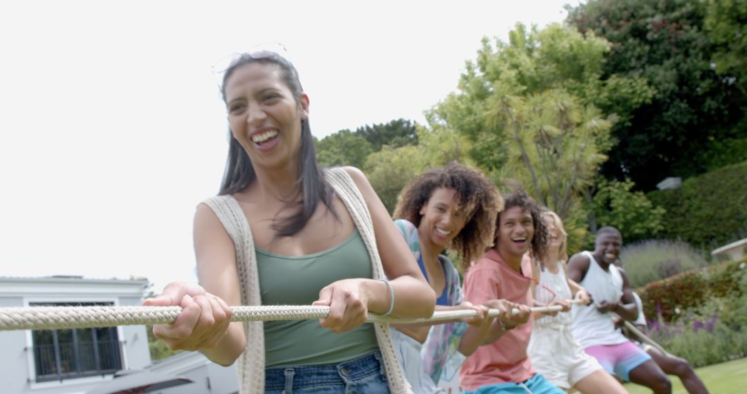Diverse Friends Enjoy Outdoor Tug of War Game Enthusiastically
