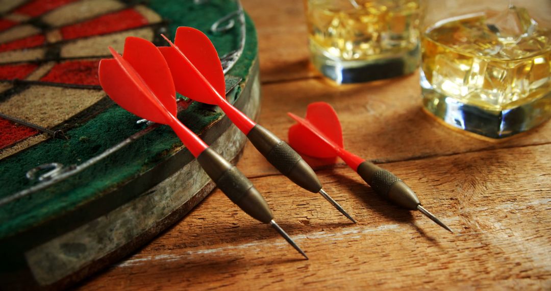 Red Darts on Dartboard with Whiskey Glasses on Wooden Table - Free Images, Stock Photos and Pictures on Pikwizard.com