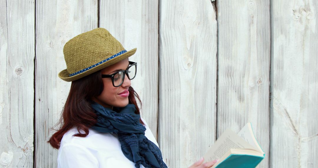 Woman Reading Book Outdoors by Wooden Wall - Free Images, Stock Photos and Pictures on Pikwizard.com