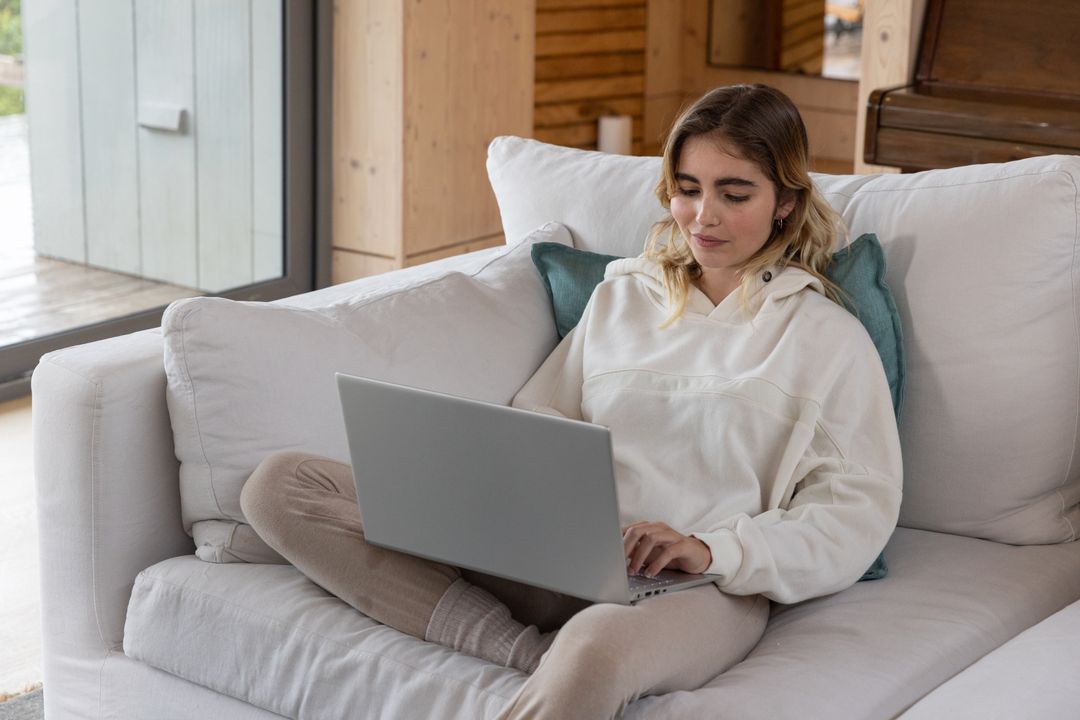 Woman Relaxing with Laptop in Cozy Modern Cabin Setting