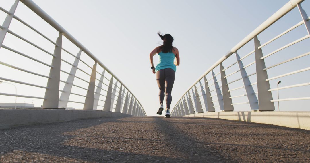 Woman Jogging on Bridge for Morning Workout - Free Images, Stock Photos and Pictures on Pikwizard.com