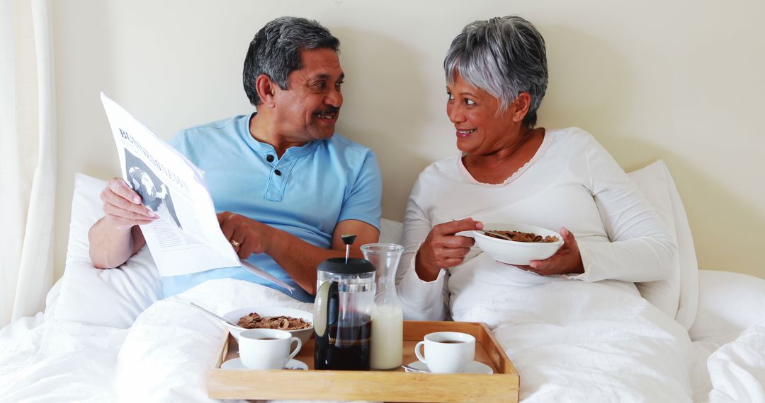 Happy Middle-Aged Hispanic Couple Enjoying Breakfast in Bed