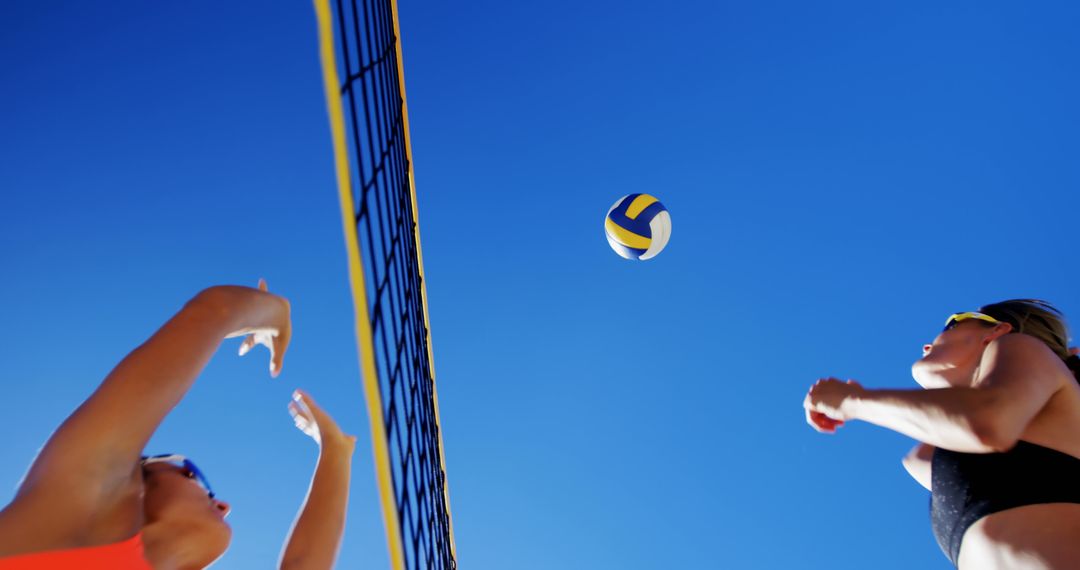 Low Angle Shot of Women's Beach Volleyball Game - Free Images, Stock Photos and Pictures on Pikwizard.com