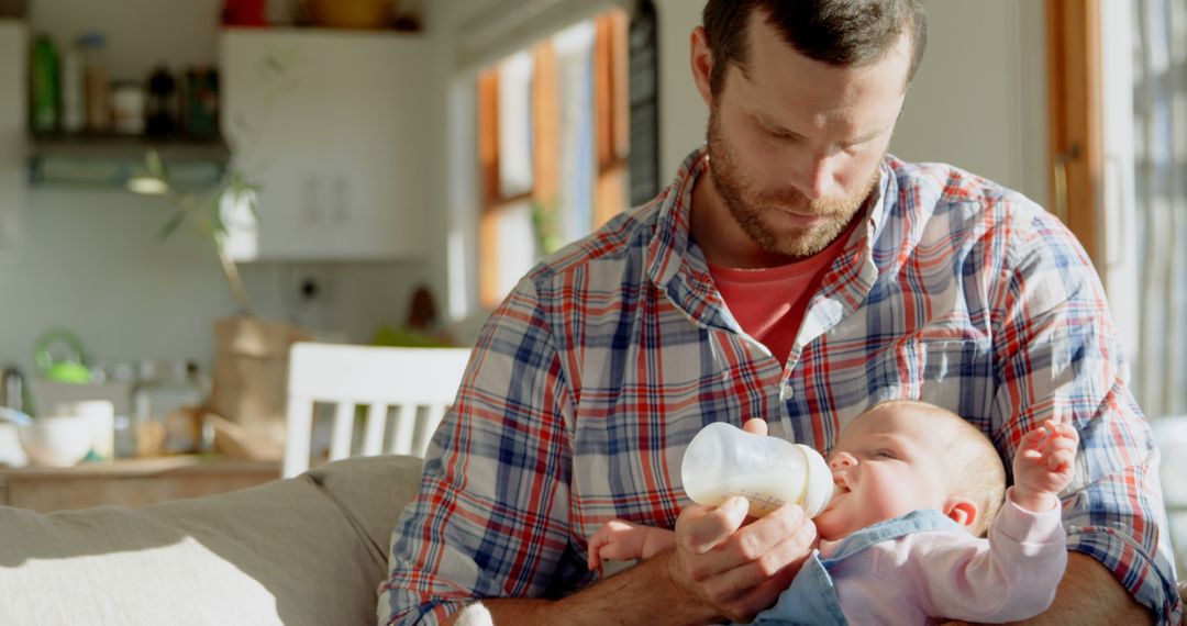 Father Feeding Baby with Bottle in Sunlit Living Room - Free Images, Stock Photos and Pictures on Pikwizard.com