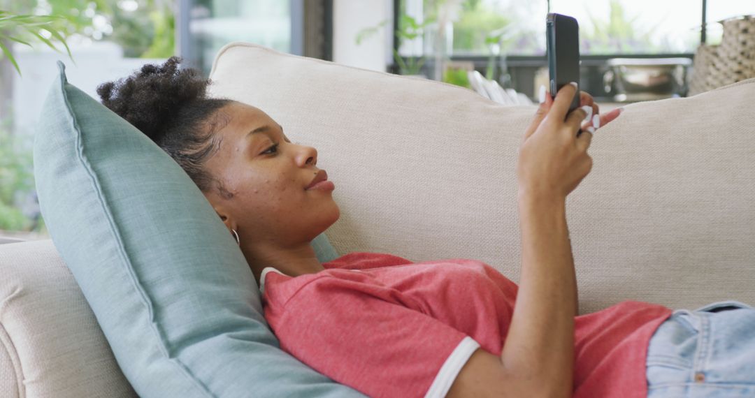 Relaxed Woman Lying on Couch Using Smartphone at Home - Free Images, Stock Photos and Pictures on Pikwizard.com