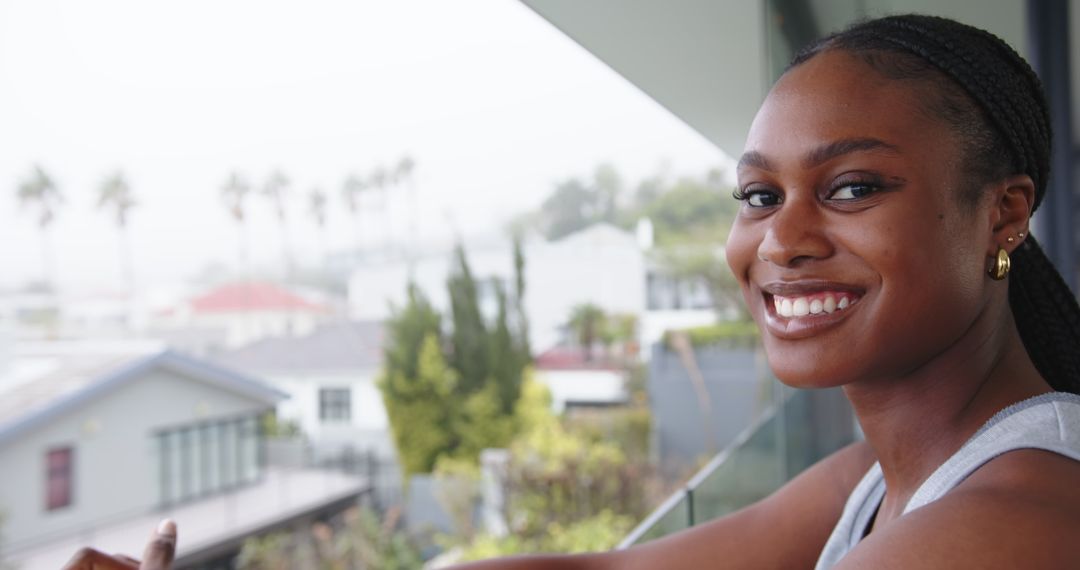 Content Woman on Balcony with Urban Backdrop