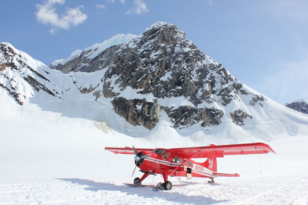 Red Plane Parked on Snowy Mountain at Clear Sky Day - Free Images, Stock Photos and Pictures on Pikwizard.com
