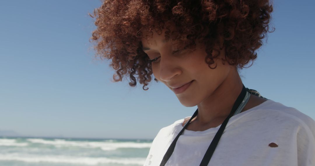 Smiling Woman with Curly Hair Enjoying Beach Day - Free Images, Stock Photos and Pictures on Pikwizard.com