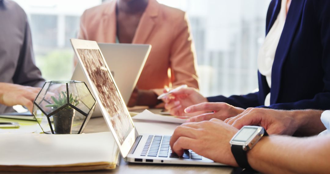 Collaborative Team Meeting with Laptops in Modern Workspace