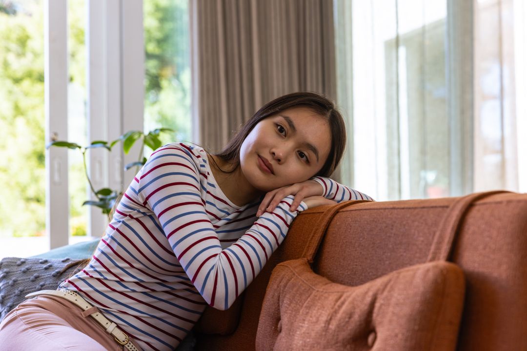 Woman Relaxing and Thinking on Sofa in Cozy Home Environment