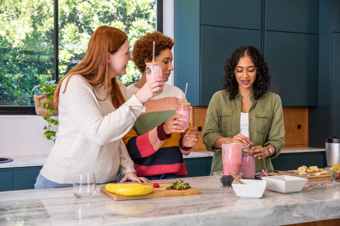 Diverse Friends Enjoying Smoothie-Making in Modern Kitchen
