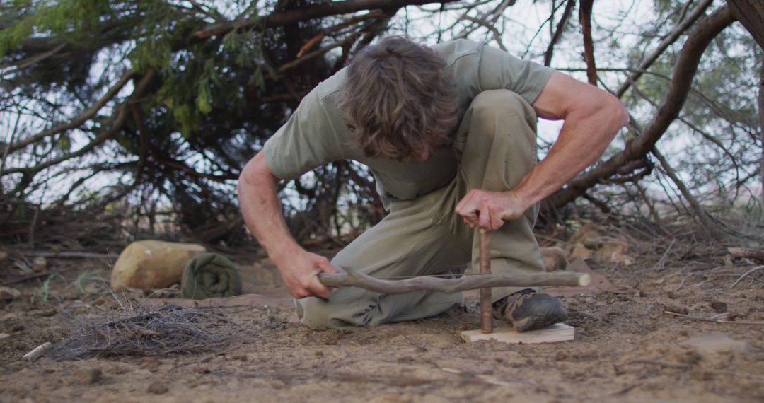 Man Starting Fire with Bow Drill Method in Wilderness - Free Images, Stock Photos and Pictures on Pikwizard.com