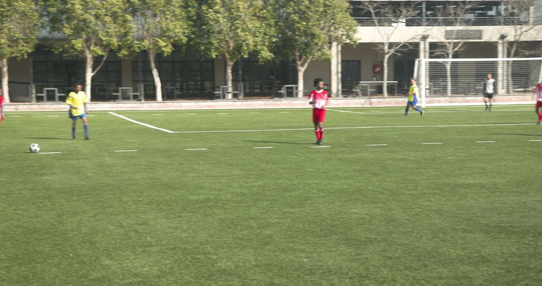 Youth Soccer Players Competing on School Field Focusing on Teamwork