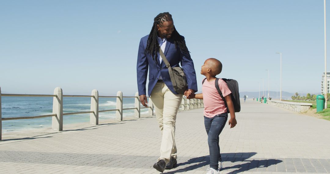 Happy African American Father and Son Walking Along Beachfront - Free Images, Stock Photos and Pictures on Pikwizard.com