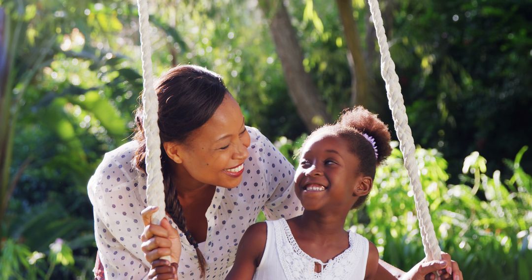 Mother and Daughter Smiling Together on Swing in Park - Free Images, Stock Photos and Pictures on Pikwizard.com