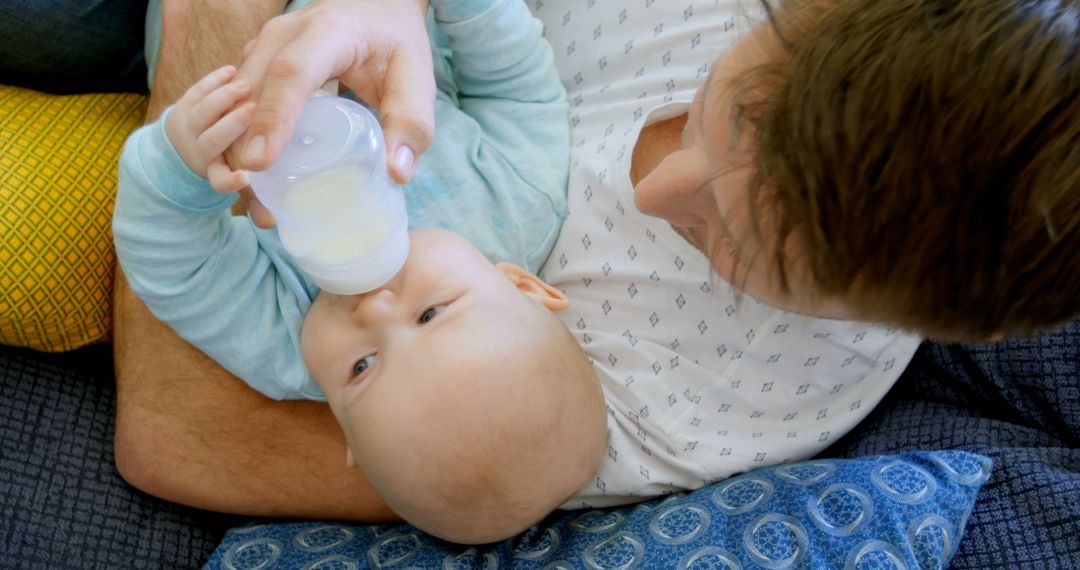 Father Feeding Baby with Bottle While Sitting on Couch - Free Images, Stock Photos and Pictures on Pikwizard.com