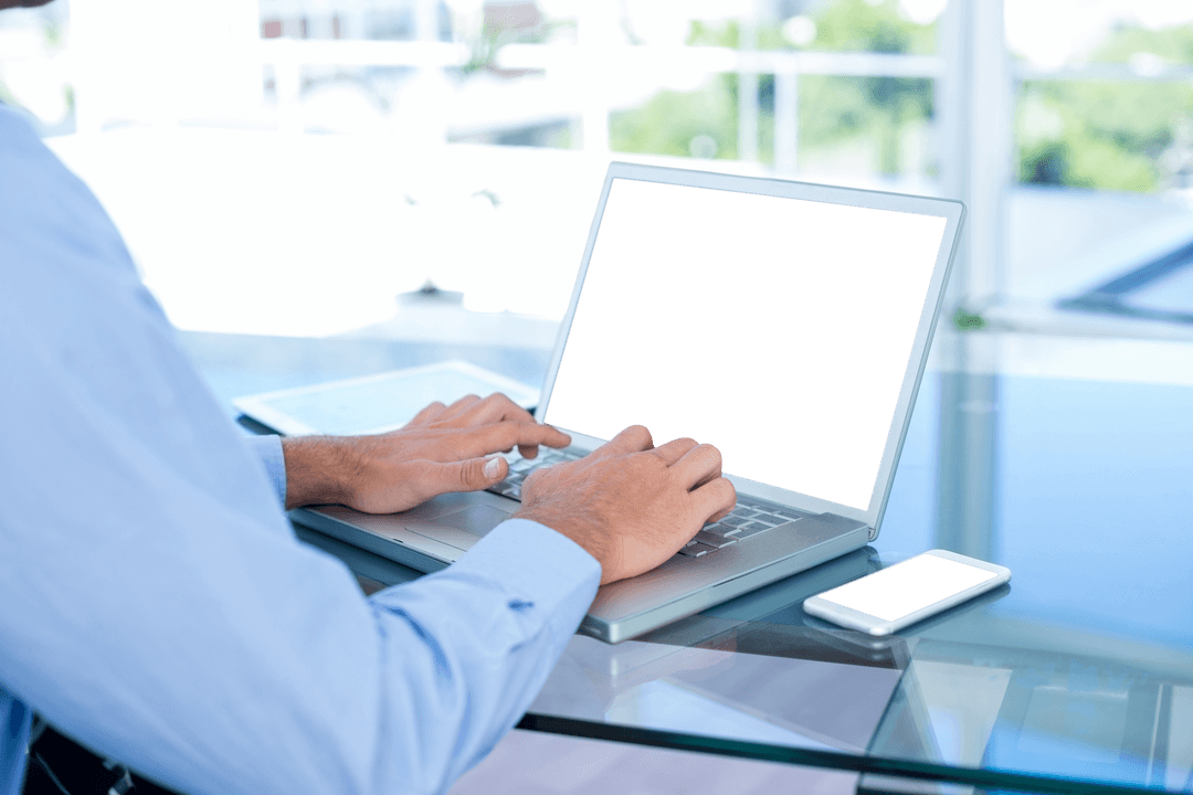 Man in Blue Shirt Typing on Transparent Laptop at Office Desk