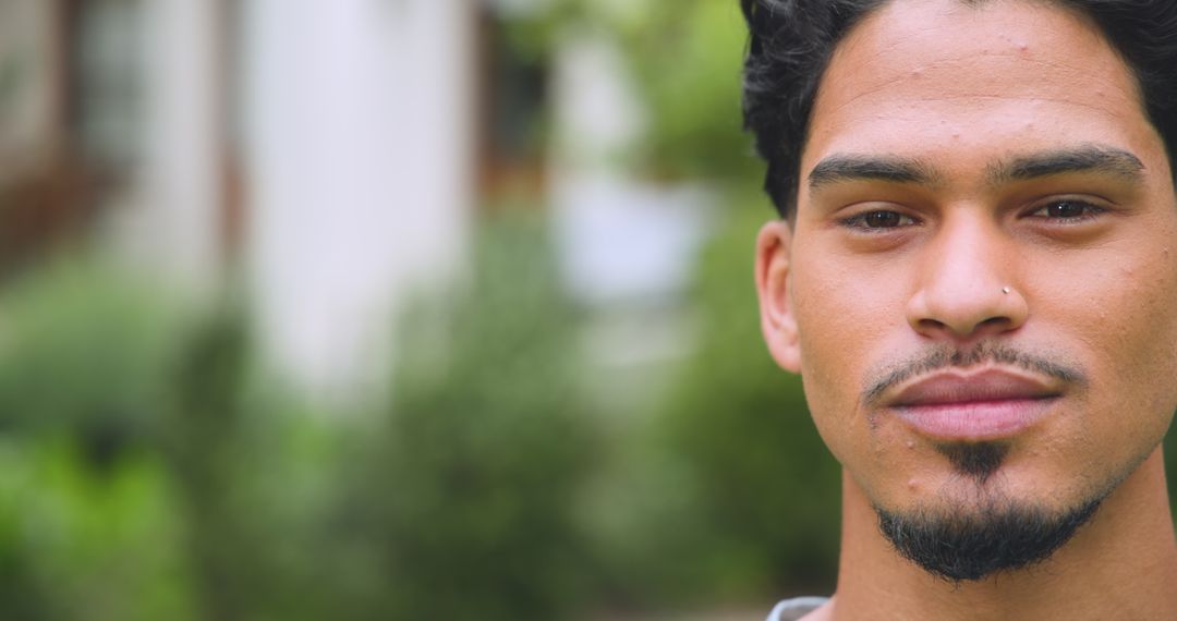 Confident Young Man with Nose Stud in Garden Setting