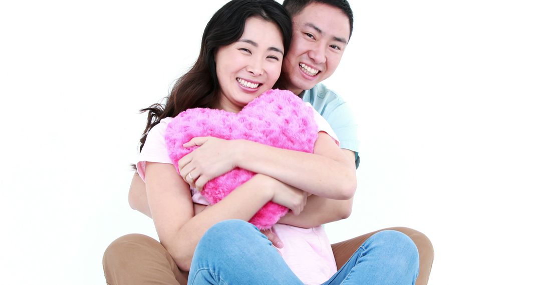 Smiling Couple Holding Heart Shaped Pillow Celebrating Love - Free Images, Stock Photos and Pictures on Pikwizard.com