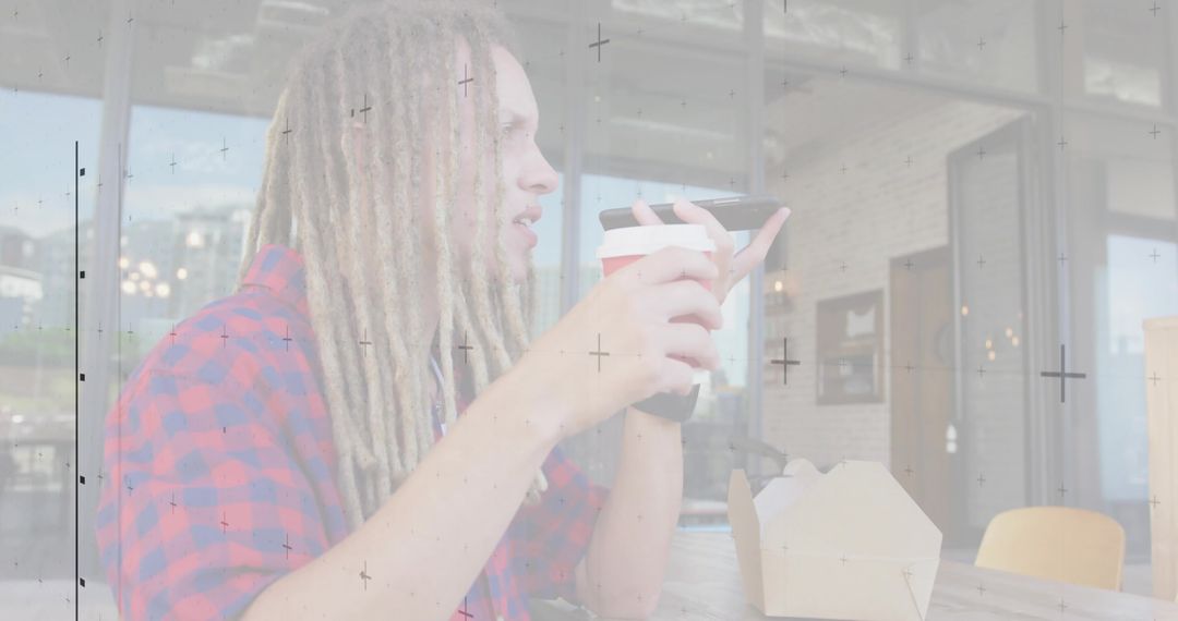 Young Man with Dreadlocks Talking on Smartphone in Cafe