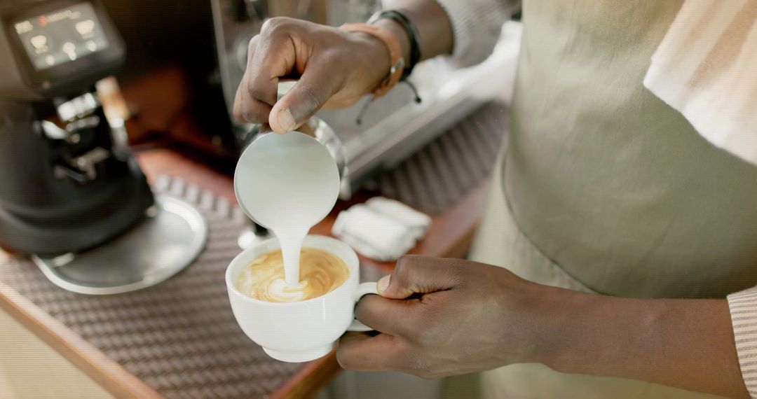 Barista Skillfully Creating Latte Art in a Cozy Cafeteria Atmosphere