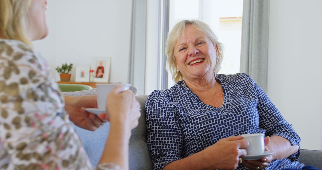 Senior Woman Enjoying Tea and Laughing with Friend at Home - Free Images, Stock Photos and Pictures on Pikwizard.com