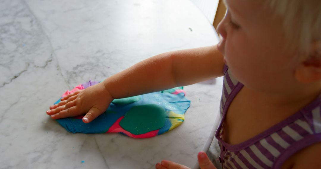 Child Engaging in Creative Play with Colorful Clay at Home