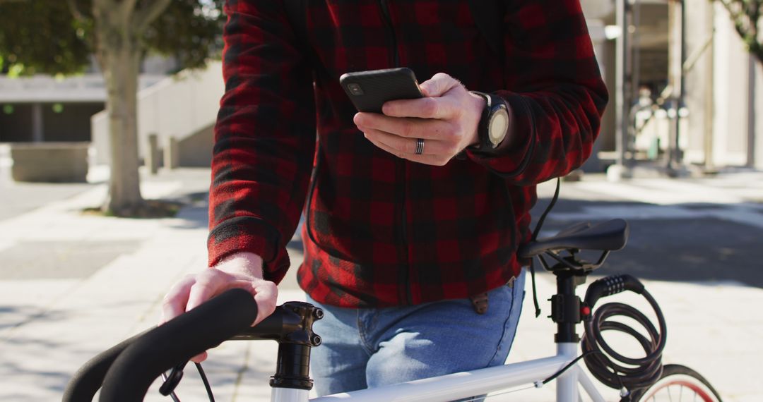 Cyclist Texting on Smartphone While Walking Bicycle on Sunny Day - Free Images, Stock Photos and Pictures on Pikwizard.com