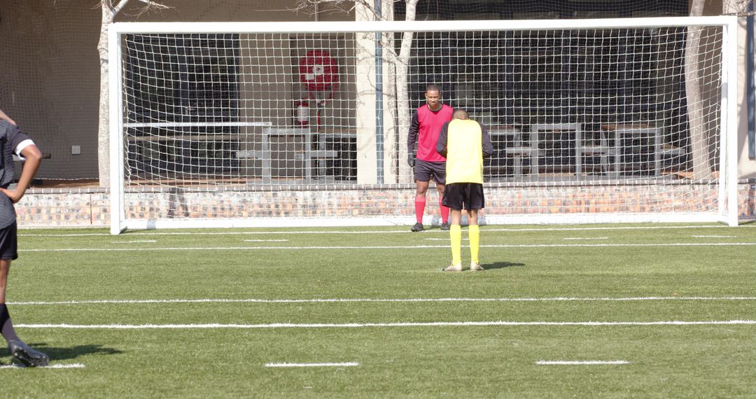 Soccer Player Kicking Ball Towards Goal in Practice Match
