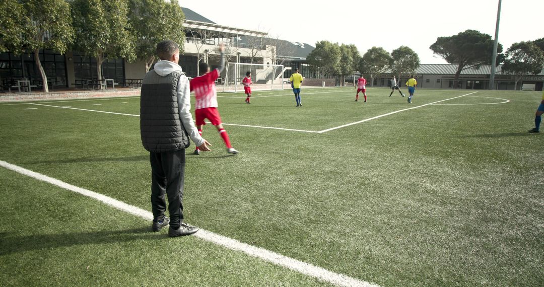 Youth Soccer Coach Observing Practice on Field
