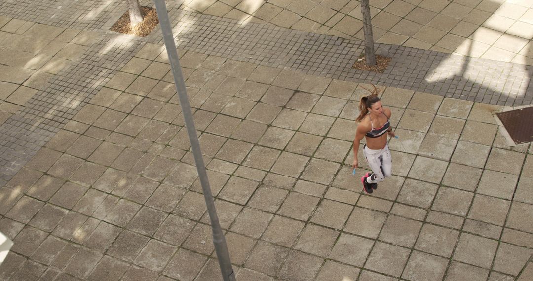 Runner in Athletic Wear Jogging on Urban Pavement - Free Images, Stock Photos and Pictures on Pikwizard.com