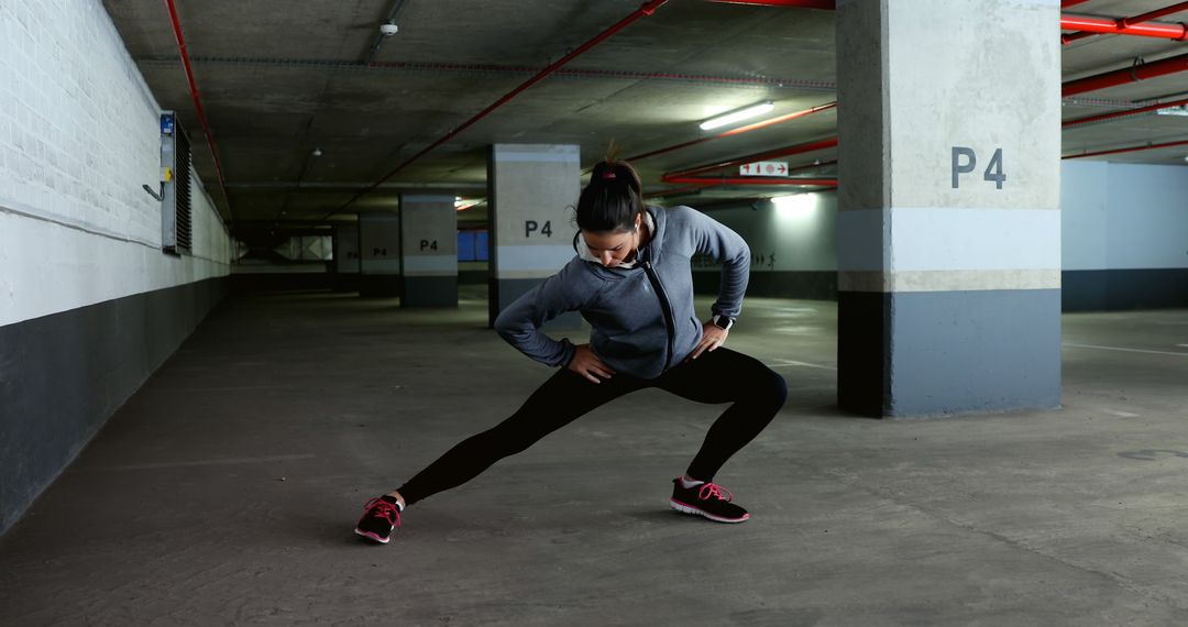 Woman Stretching in Underground Parking Garage for Exercise - Free Images, Stock Photos and Pictures on Pikwizard.com